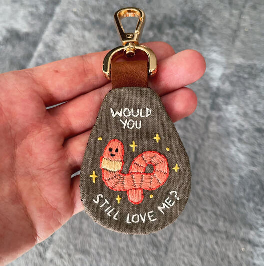 Hand embroidered keychain with a leather backing and clasp